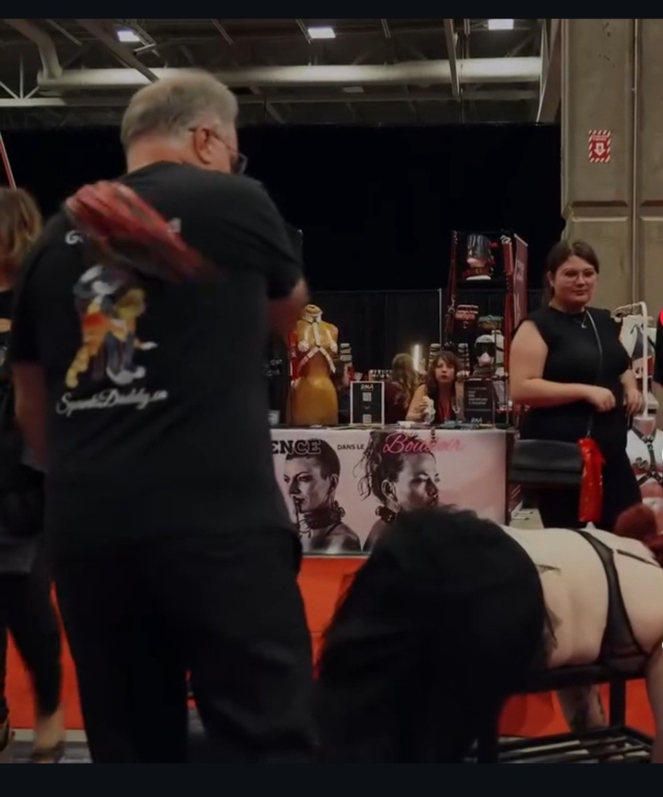 Spank Daddy demonstrating controlled sensual flogging technique at an adult lifestyle event Spank Daddy demonstrating controlled sensual flogging technique at an adult lifestyle event
